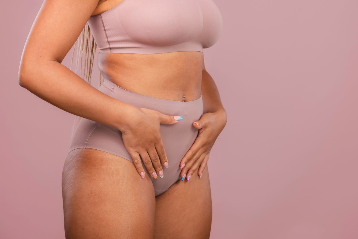 person with hands placed over stomach
